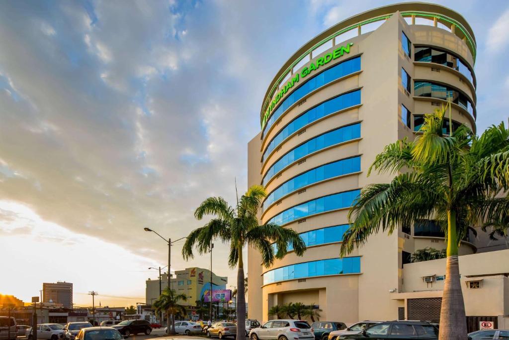 um edifício com palmeiras em frente em Wyndham Garden Guayaquil em Guayaquil