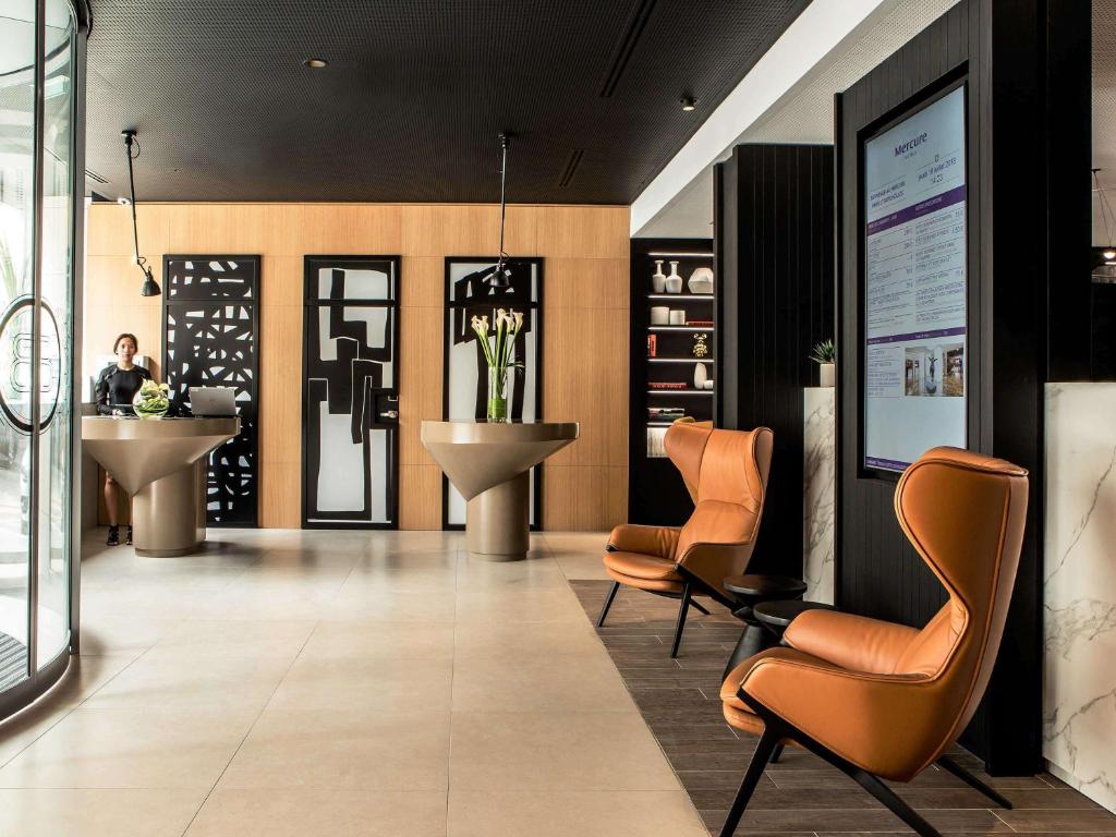 een lobby met 2 stoelen en een wastafel bij Mercure Paris 17 Batignolles in Parijs