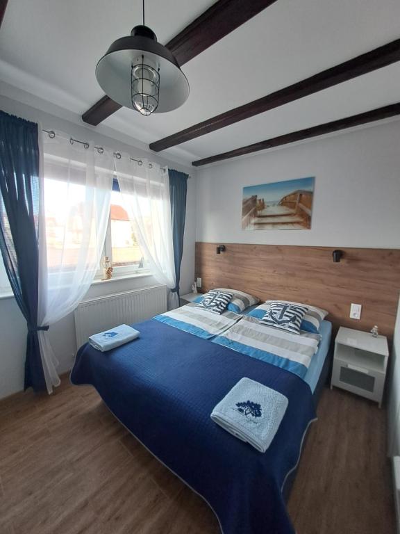 1 dormitorio con 1 cama grande con manta azul en Orzechowa Przystań, en Ustka