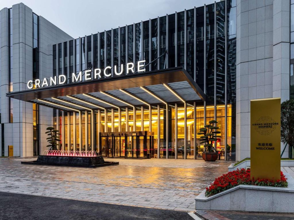 a grand mercure building with a sign in front of it at Grand Mercure Yichang Waitan in Yichang