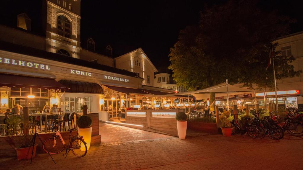 eine Gruppe von Geschäften in einer Stadtstraße nachts in der Unterkunft Inselhotel König in Norderney