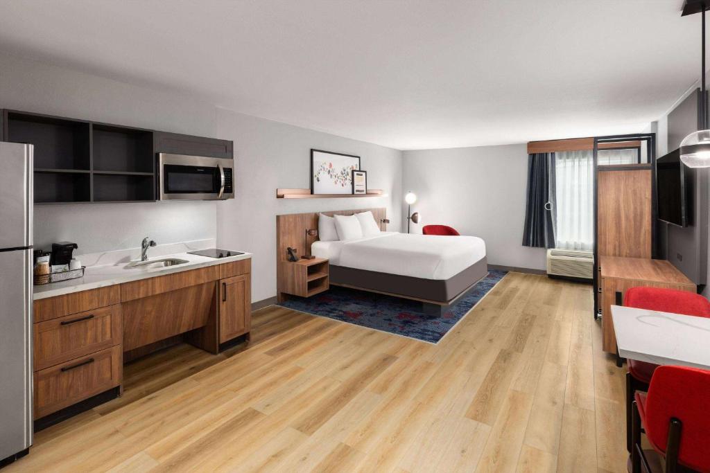a hotel room with a bed and a sink at Hawthorn Extended Stay by Wyndham Knoxville in Knoxville