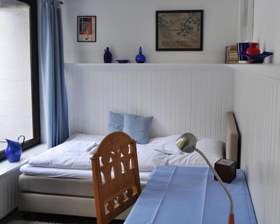 1 dormitorio con 1 cama y 1 mesa con lámpara en Atelierhaus Tannenweg, en Worpswede