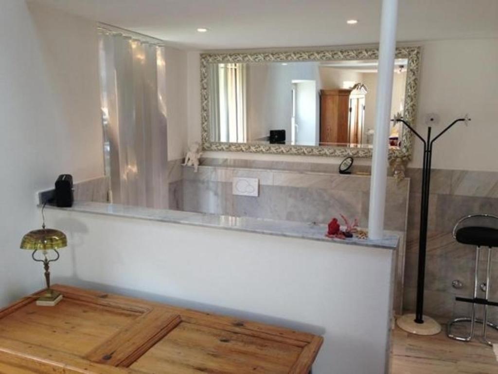 een badkamer met een bad en een grote spiegel bij Single Haus auf mehreren Ebenen - herzlich willkommen in der lichtdurchfluteten Casa Carina in Dongio