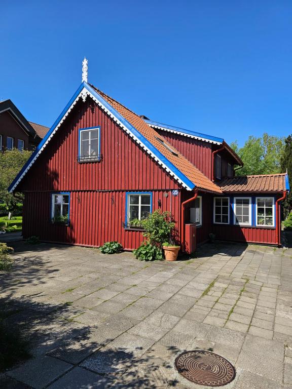 a red house with a driveway in front of it at Nidos Rojus in Nida