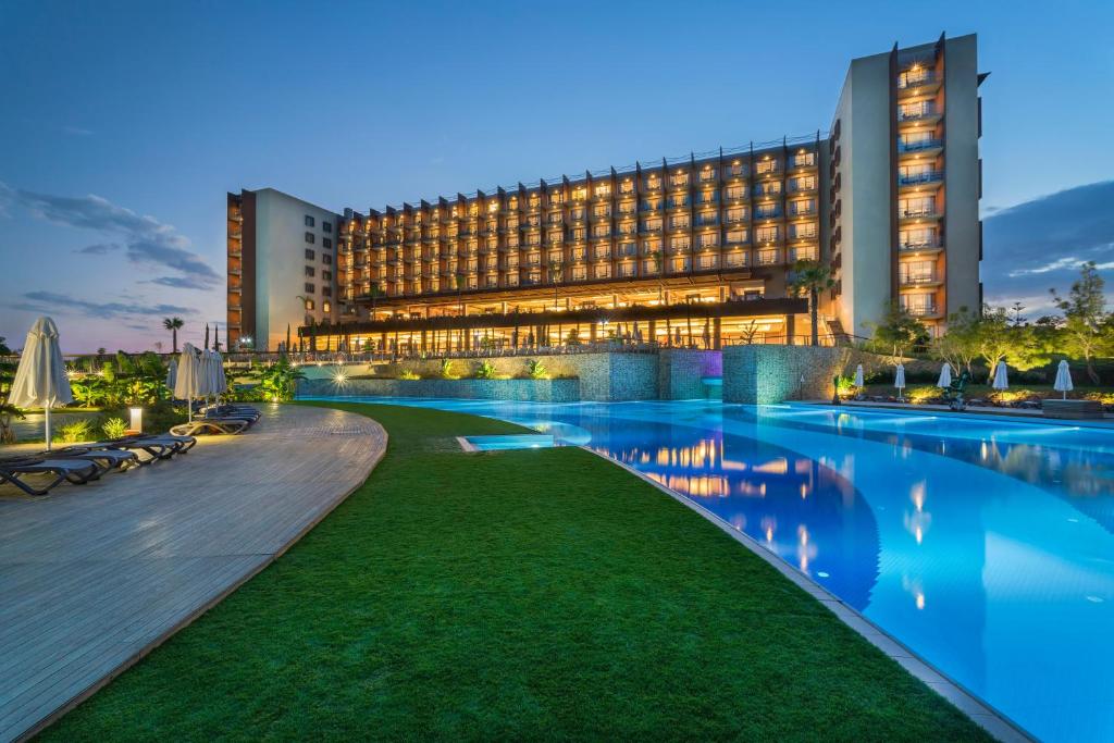 a hotel with a swimming pool in front of a building at Concorde Luxury Resort & Casino in Vokolidha