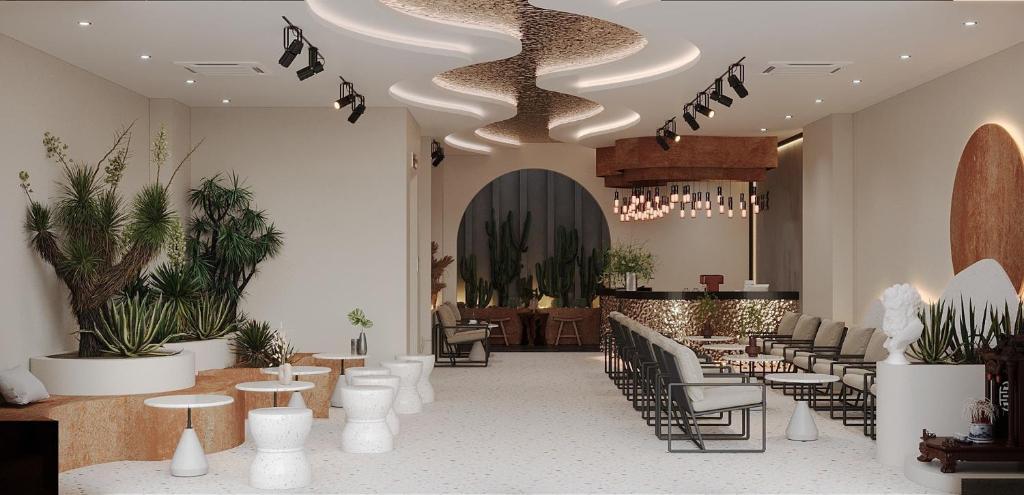 a lobby with tables and chairs and plants at Olive SamSon Hotel in Sầm Sơn