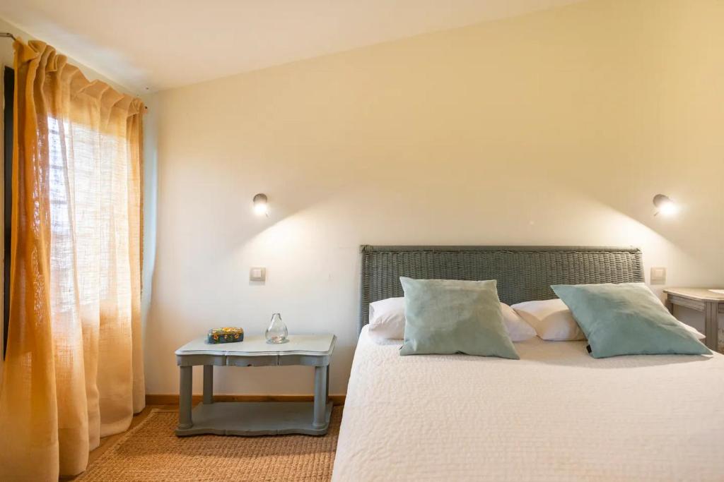 a bedroom with a bed with a side table at B&B Mas Coquells Habitación Genover in Vilanant