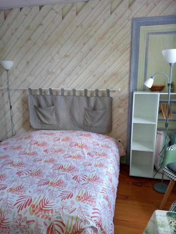 une chambre avec un lit et un mur en bois dans l'établissement Studio Continental côté jardin, à Vittel