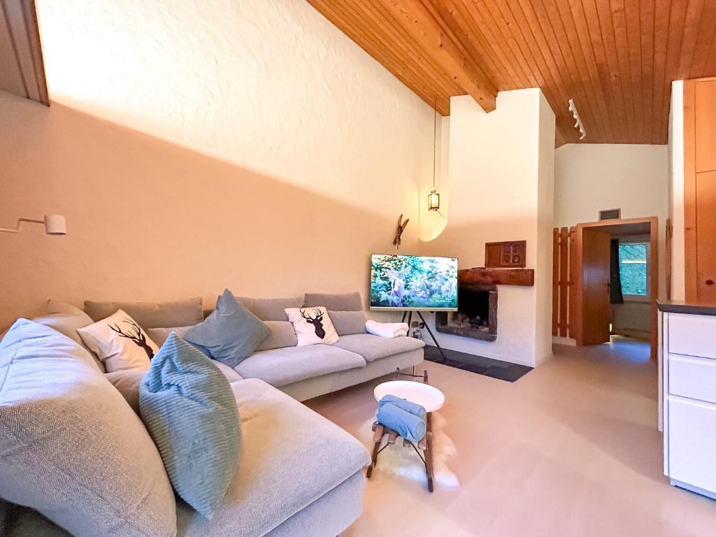 a living room with a couch and a tv at Apartment Bodmi on the top in Grindelwald