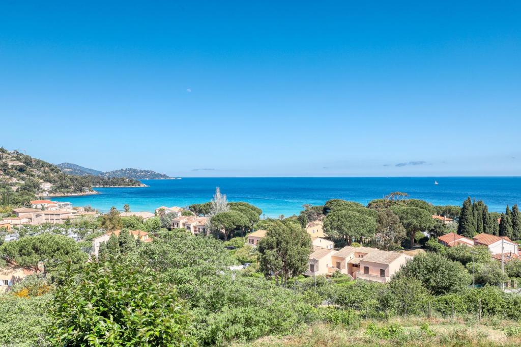 a village on a hill with the ocean in the background at T2 vue mer à Saint-Clair in Le Lavandou