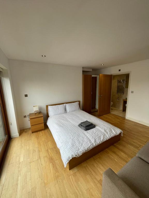 ein Schlafzimmer mit einem weißen Bett und einem Sofa in der Unterkunft London City Ensuite Room City Airport&London Excel Exhibition Center in London