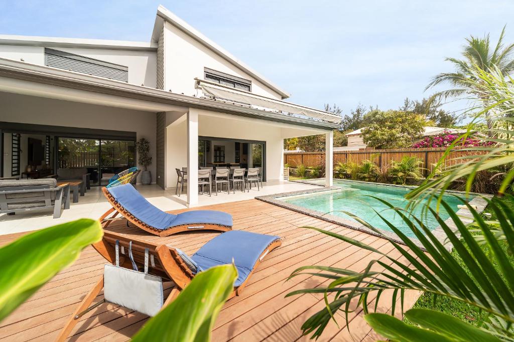 a patio with chairs and a swimming pool at Villa Ilyana - bord de mer- piscine chauffée in La Saline les Bains