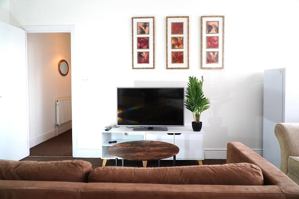 - un salon avec un canapé et une télévision dans l'établissement 2 Bedroom Apartment Brierley Hill, à Brierley Hill