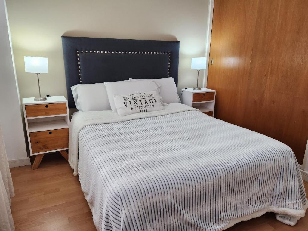 um quarto com uma cama grande e um cobertor listrado em DEPARTAMENTO WITCOMB Con Estacionamiento em Bahía Blanca