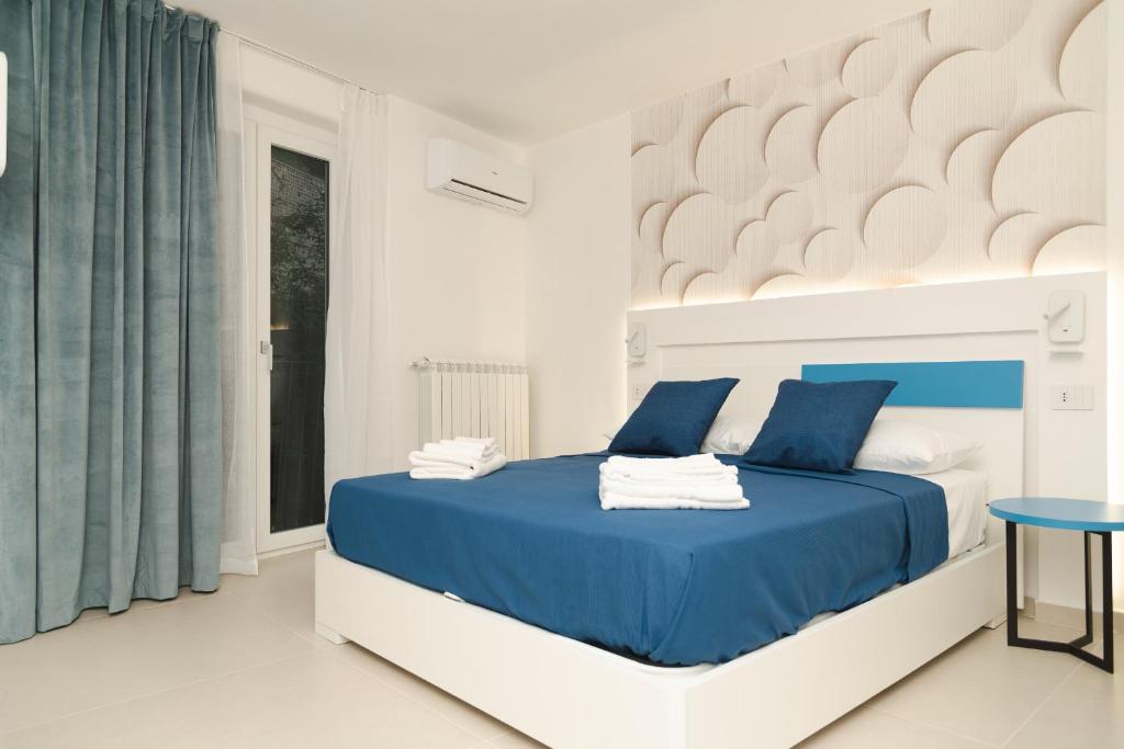 ein Schlafzimmer mit einem blauen Bett und einem Fenster in der Unterkunft La Chicca Apartments Castellammare Di Stabia in Castellammare di Stabia