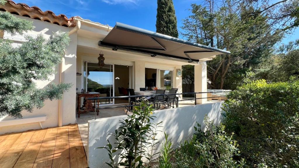 une maison avec une terrasse en bois et un parasol dans l'établissement Superbe Villa EmmaZen climatisée, à Sainte-Maxime