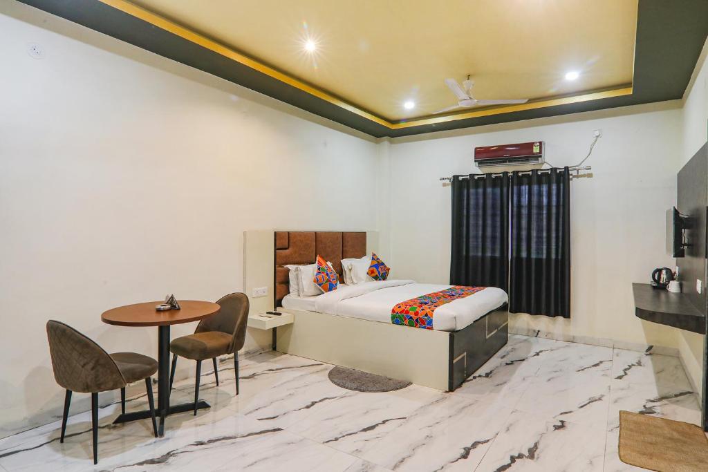 a bedroom with a bed and a table and chairs at FabHotel Saalt Bandhan Resort in Muzaffarpur
