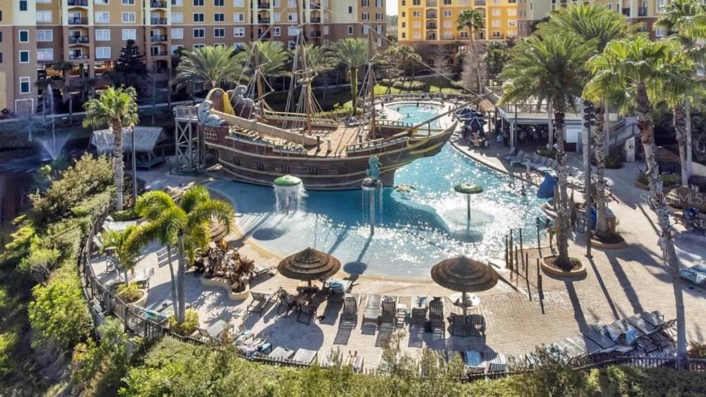 a large pool in a resort with a boat in it at Pirate Ship Resort Condo in Orlando