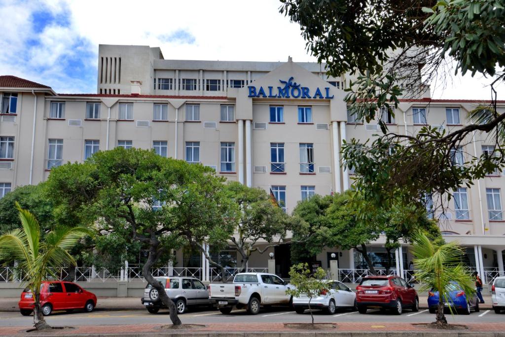 un gran edificio con coches estacionados frente a él en The Balmoral, en Durban