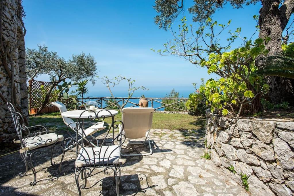un tavolo e sedie seduti su un patio in pietra di La Cisterna, not only landscape ad Anacapri