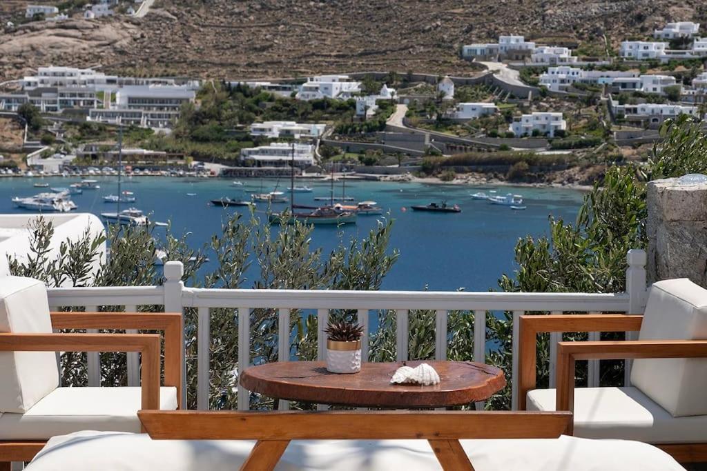 a table on a balcony with a view of a harbor at Ornos Vibes 1 in Mikonos