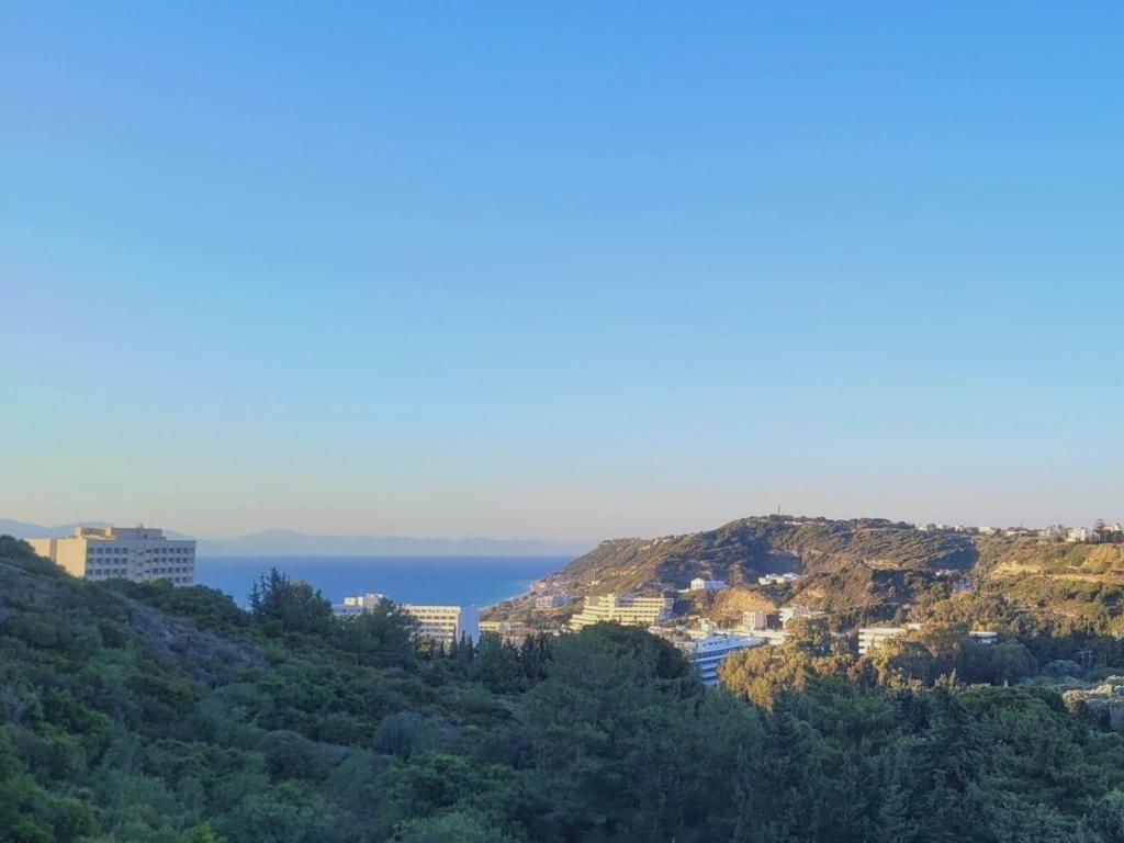 a view of the ocean and buildings on a hill at Monte Mare Rhodes in Ixia