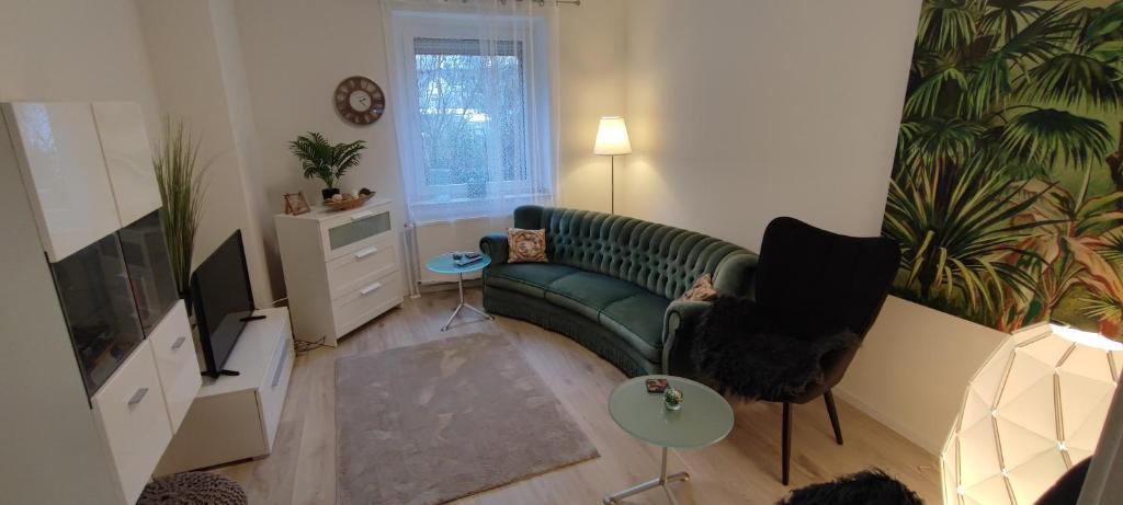 sala de estar con sofá verde y TV en Juwel im Zentrum Terrasse+Garten 75m², en Mönchengladbach