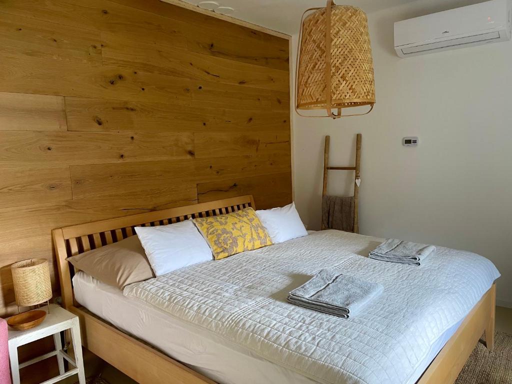 ein Schlafzimmer mit einem Bett mit einer Holzwand in der Unterkunft Patika Vendeghaz in Őriszentpéter