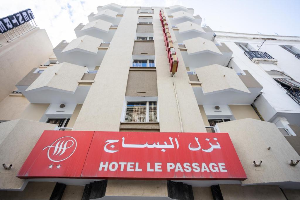 una señal de hotel frente a un edificio en Hôtel le passage en Túnez