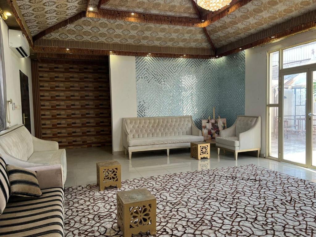 uma sala de estar com um sofá e duas cadeiras em سرايا الياسمين em Ilbaras