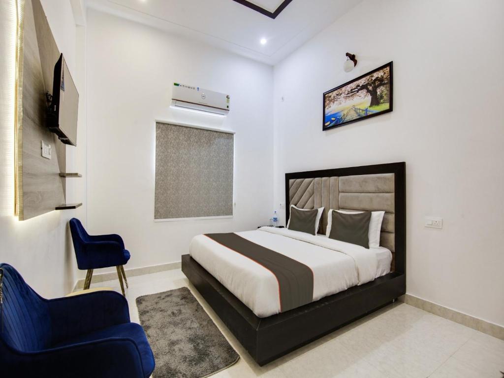 ein Schlafzimmer mit einem Bett und einem blauen Stuhl in der Unterkunft The Nines hotel & restro in Kālādhūngi
