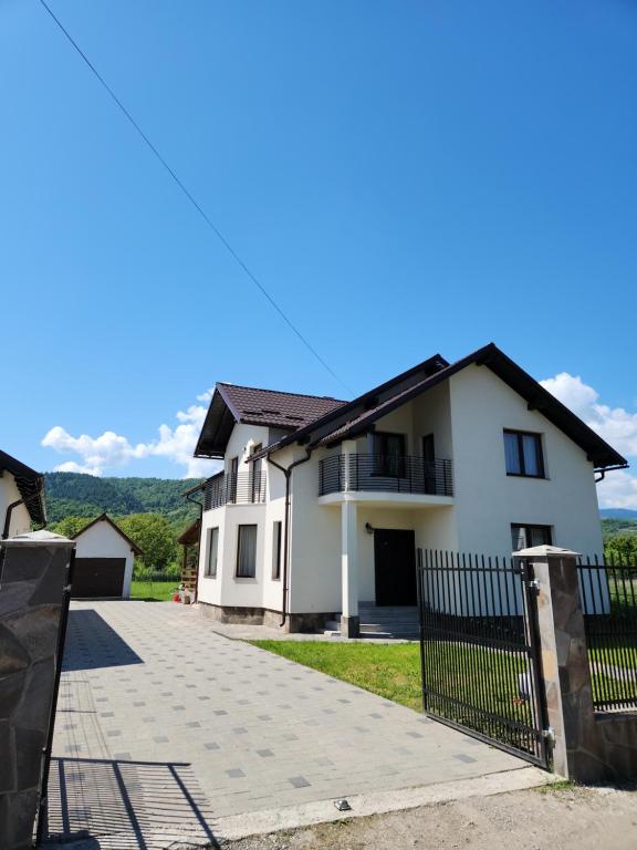 una casa blanca con valla y entrada en Casa CLO, en Sighetu Marmaţiei