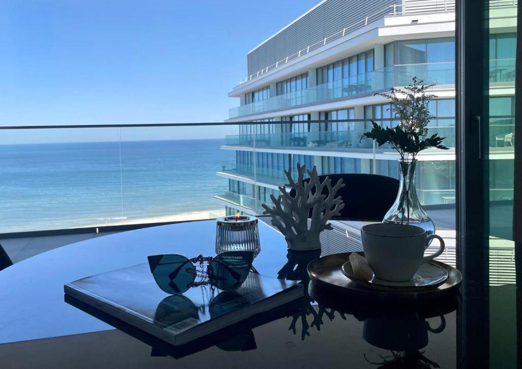 una mesa con una taza de café sobre una mesa con vistas al océano en The SKY by Wave Międzyzdroje Resort&SPA en Międzyzdroje