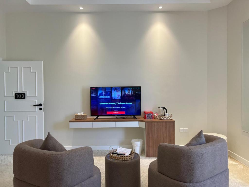 een woonkamer met 2 stoelen en een flatscreen-tv bij Halima Shared Housing - Female only in Dubai