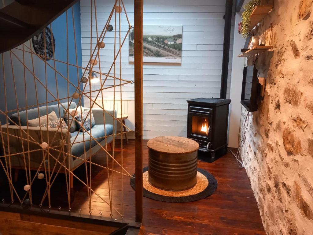um quarto com um fogão a lenha e um sofá em L'Atelier - Gîte urbain chaleureux em Saint-Hubert
