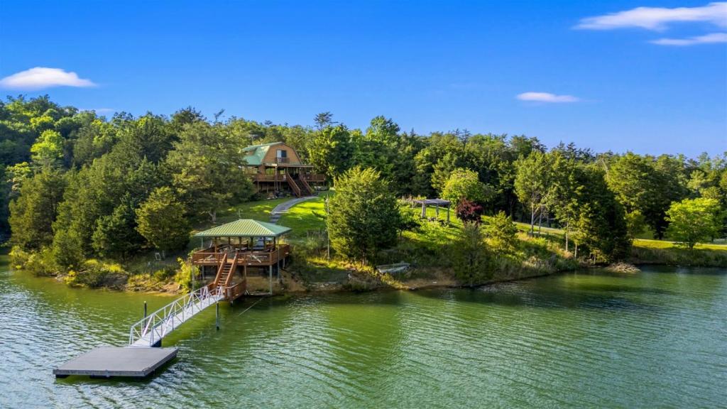 an island in the middle of a lake with a house at Lakefront Retreat With Mountain Views, Private Boat Launch And Dock in Sevierville