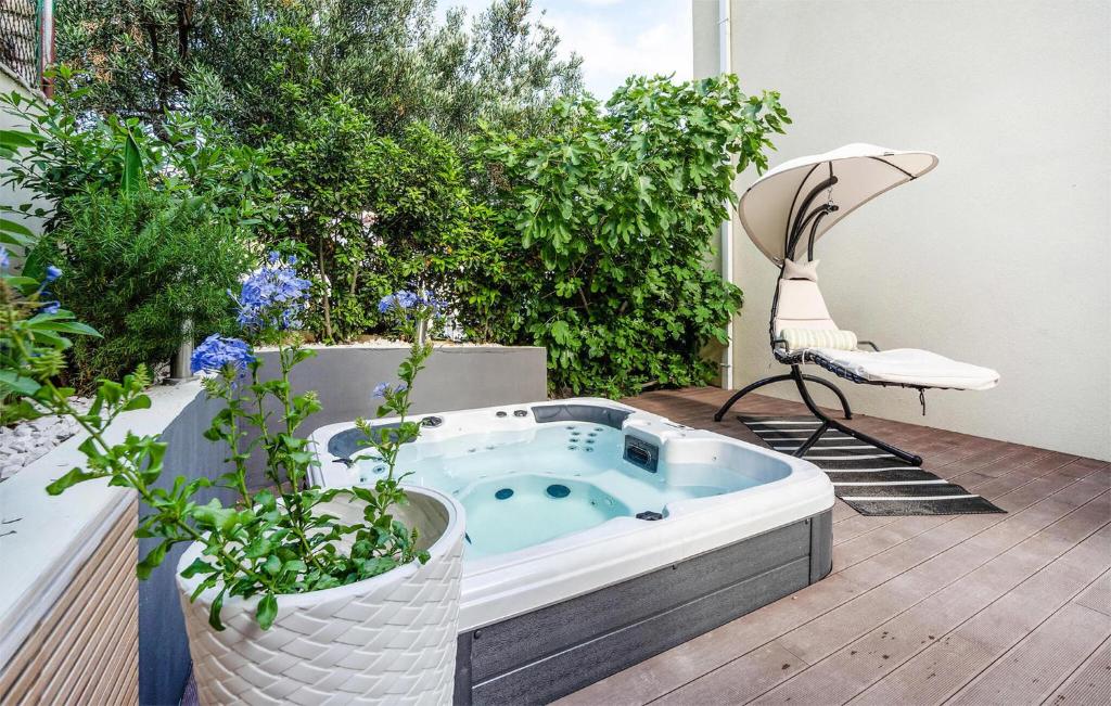 a hot tub sitting on a deck with plants at Pet Friendly Apartment In Podstrana With Wifi in Podstrana