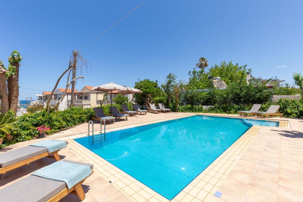 - une piscine avec des chaises longues et des chaises à côté d'une maison dans l'établissement Villa Armonia Chania, à Kato Galatas