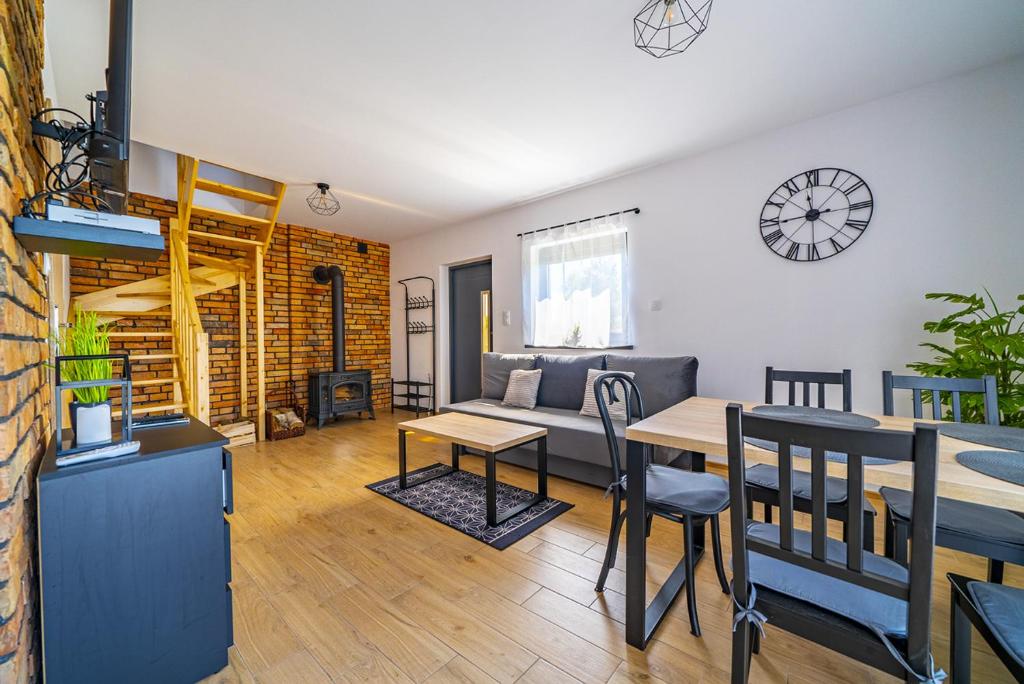 una sala de estar con un sofá y una mesa en Całoroczny Domek Bosmańska, en Lubiatowo