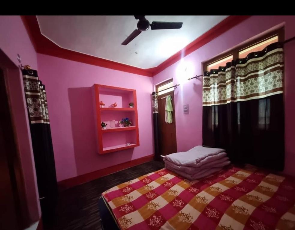 UkhimathにあるKailash torisht logeのピンクの壁のベッドルーム1室(ベッド1台付)