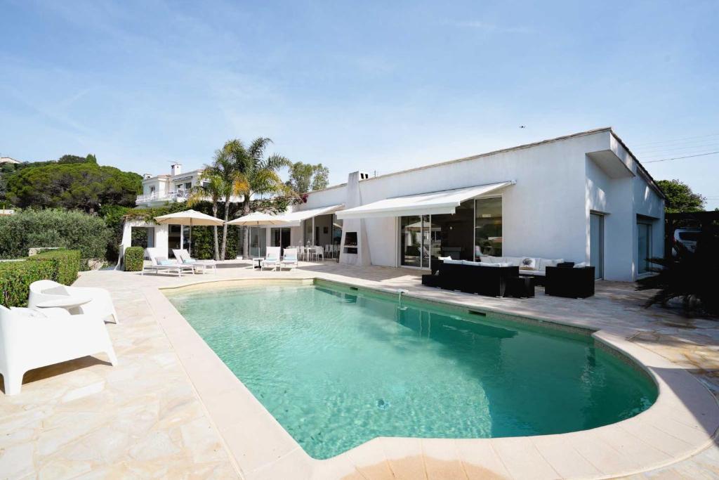 une piscine devant une maison dans l'établissement Villa Paradiso Luxe, à Cannes