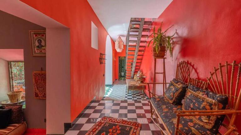 マラケシュにあるRiad OLIVE Privatif 4 Personnesの赤い壁とチェッカーフロアのリビングルーム