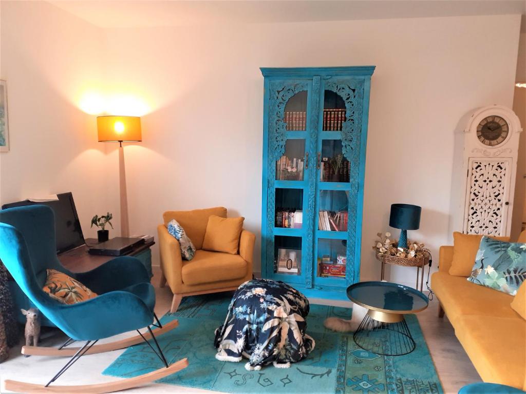 un salon avec des chaises et un meuble bleu dans l'établissement L'hortensia bleu, à Saint-Malo