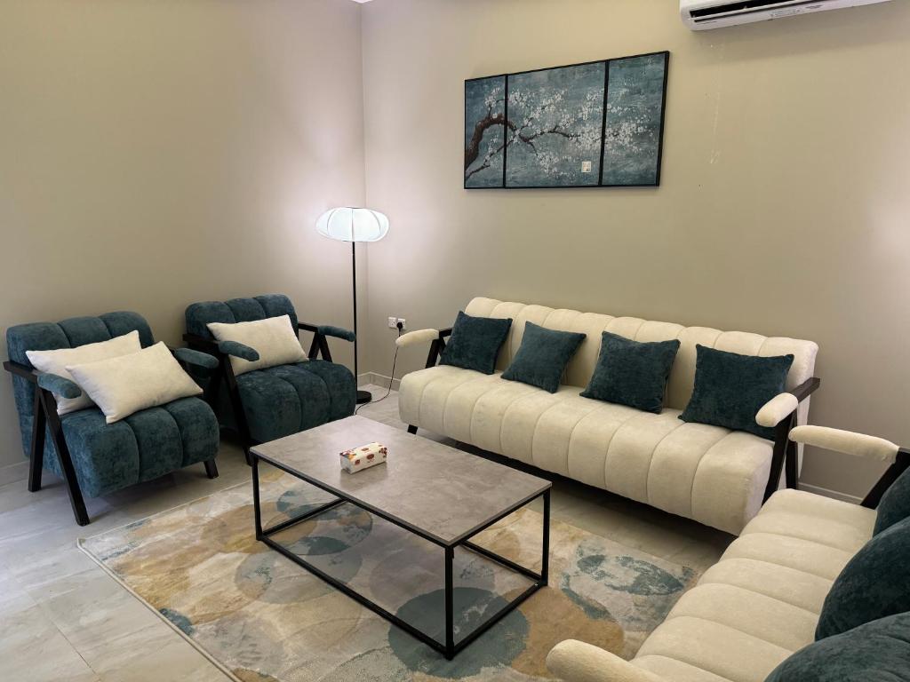 salon z kanapą, 2 krzesłami i stołem w obiekcie Elegant Apartment in Al-Narjis شقة أنيقة بثلاث غرف وصالة تسجيل ذاتي w Rijadzie
