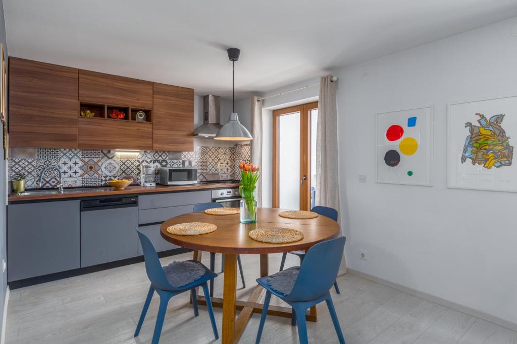 a kitchen with a wooden table and blue chairs at Apartment Blu in Poreč
