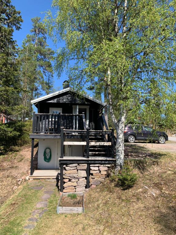 una piccola casa con un portico e un albero di Gilleråsvägen 13 C a Sälen