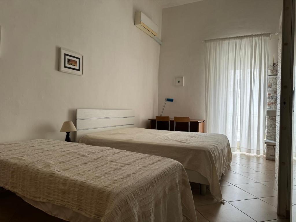 um quarto de hotel com duas camas e uma janela em Peschici a un passo em Peschici