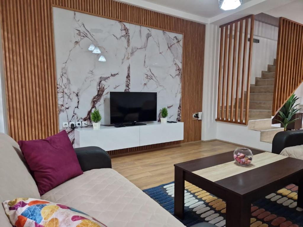 a living room with a couch and a tv at Town Square House in Gevgelija