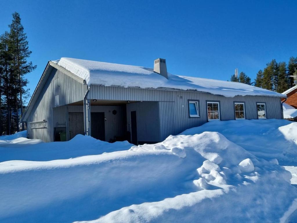 uma casa coberta de neve com uma pilha de neve em Ferienhaus Villa Edda in Vidsel mit Garten und Terrasse em Vidsel